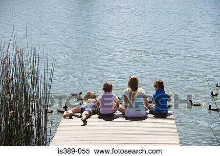 Children feeding ducks on a lake View Large Photo Image Stock Photography - Children feeding ducks on a lake. Fotosearch