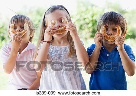 Stock Photo - Children holding croissants to faces. Fotosearch