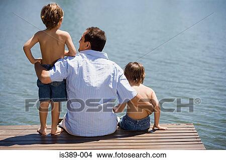 Father and sons on a wooden pier View Large Photo Image Picture - Father and sons on a wooden pier. Fotosearch
