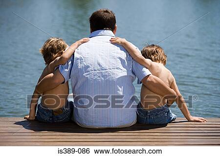 Father and sons on a wooden pier View Large Photo Image Stock Photograph - Father and sons on a wooden pier. Fotosearch