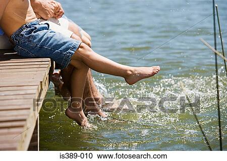 Stock Image - Father and sons splashing in lake. Fotosearch