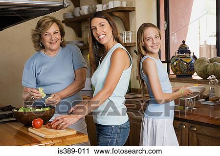 Stock Image - Female members of a family preparing a salad. Fotosearch