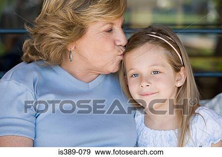 Grandmother kissing granddaughter View Large Photo Image Stock Photo - Grandmother kissing granddaughter. Fotosearch