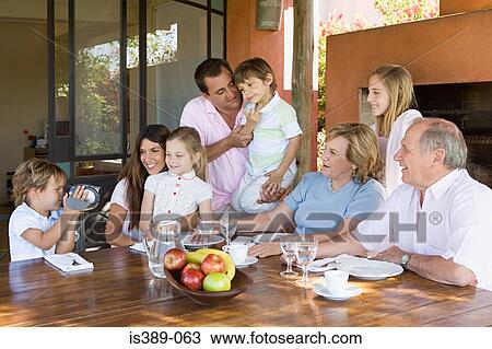 Three generation family at dining table View Large Photo Image Stock Image - Three generation family at dining table. Fotosearch