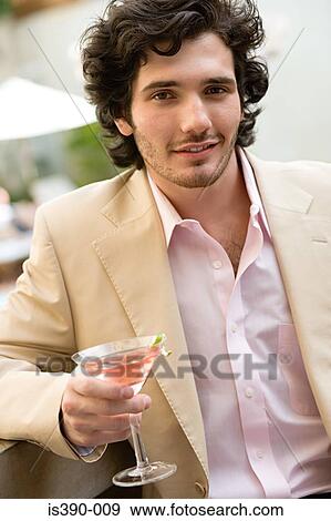 Man holding a cocktail View Large Photo Image Stock Photo - Man holding a cocktail. Fotosearch