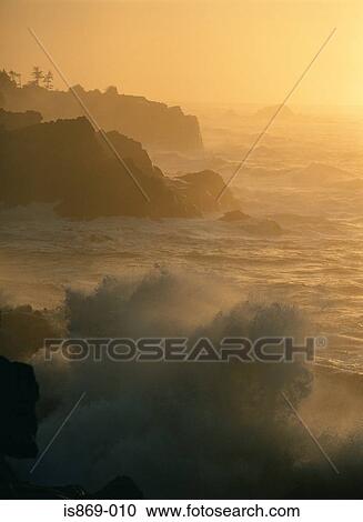 Stock Image - Waves against rocks. Fotosearch