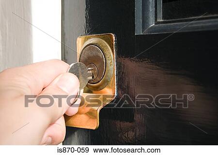 Stock Photo - Person putting key in keyhole. Fotosearch