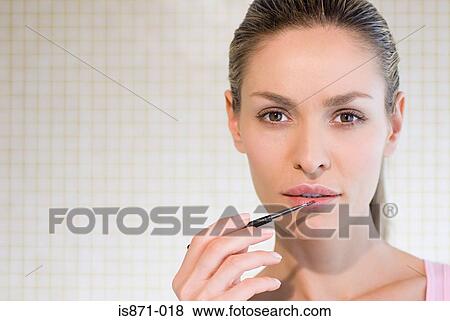 Stock Photo - Woman applying lipstick. Fotosearch