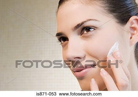 Stock Image - Woman applying moisturiser. Fotosearch