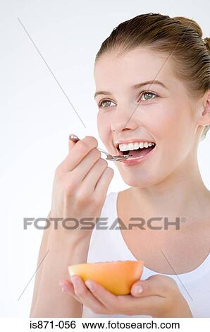 Woman eating grapefruit View Large Photo Image Stock Photograph - Woman eating grapefruit. Fotosearch