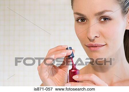 Woman holding nail varnish View Large Photo Image Stock Photo - Woman holding nail varnish. Fotosearch