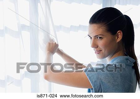 Woman pulling curtain View Large Photo Image Picture - Woman pulling curtain. Fotosearch