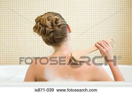 Woman scrubbing back View Large Photo Image Stock Photo - Woman scrubbing back. Fotosearch