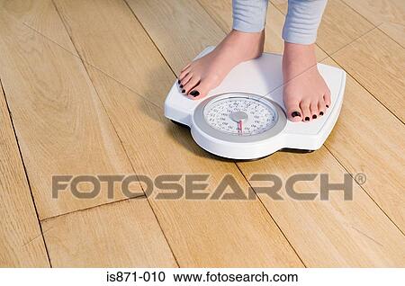 Woman standing on weight scales View Large Photo Image Stock Image - Woman standing on weight scales. Fotosearch