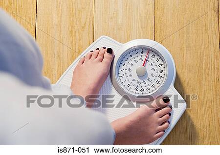 Woman standing on weight scales View Large Photo Image Stock Image - Woman standing on weight scales. Fotosearch
