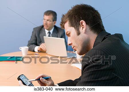 Stock Image - Businessman using hand held computer. Fotosearch
