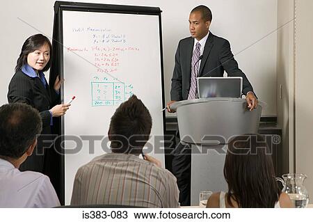 Stock Image - Businesspeople giving presentation. Fotosearch