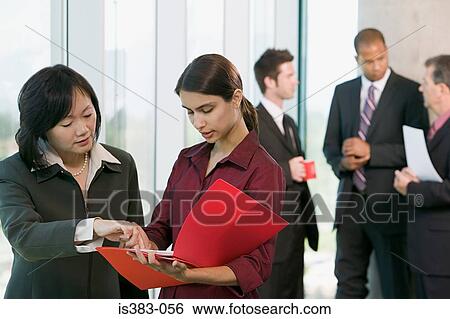 Businesswomen looking at file View Large Photo Image Stock Photograph - Businesswomen looking at file. Fotosearch