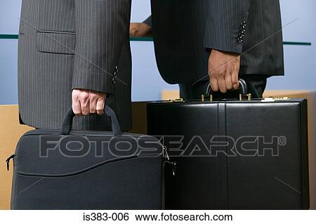 Two businessmen holding briefcases View Large Photo Image Stock Photograph - Two businessmen holding briefcases. Fotosearch