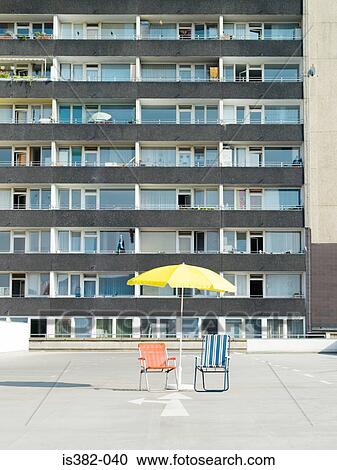 Deckchairs and parasol outside apartment building View Large Photo Image Stock Image - Deckchairs and parasol outside apartment building. Fotosearch