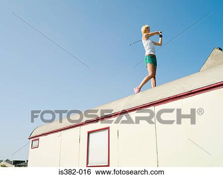 Stock Photograph - Female golfer on caravan roof. Fotosearch