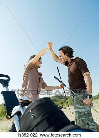 Male golfers doing high five View Large Photo Image Stock Image - Male golfers doing high five. Fotosearch