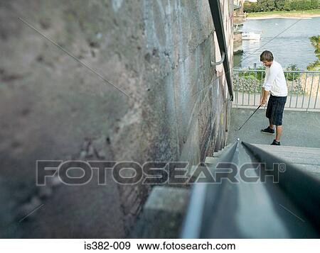Man preparing to hit golf ball up steps View Large Photo Image Stock Photo - Man preparing to hit golf ball up steps. Fotosearch