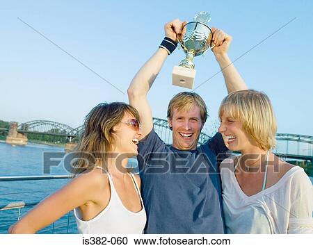 Women and man with trophy View Large Photo Image Stock Image - Women and man with trophy. Fotosearch