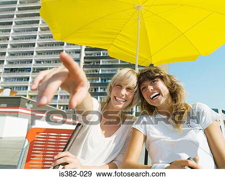 Women under parasol by apartment building View Large Photo Image Stock Photo - Women under parasol by apartment building. Fotosearch