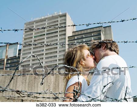 Young couple kissing in urban setting View Large Photo Image Stock Image - Young couple kissing in urban setting. Fotosearch