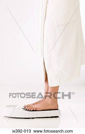 Woman standing on bathroom scales View Large Photo Image Stock Image - Woman standing on bathroom scales. Fotosearch