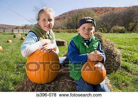 Boy and girl in field with pumpkins View Large Photo Image Stock Photo - Boy and girl in field with pumpkins. Fotosearch