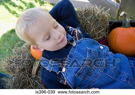 Boy asleep on hay and pumpkins View Large Photo Image Stock Photo - Boy asleep on hay and pumpkins. Fotosearch