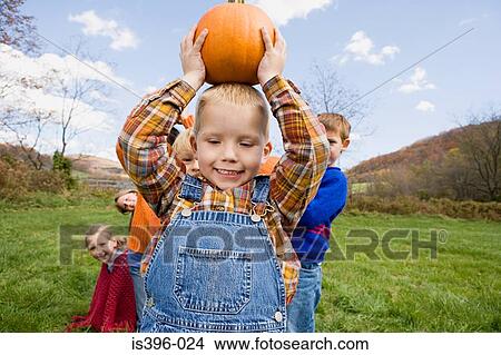 Boy holding pumpkin View Large Photo Image Picture - Boy holding pumpkin. Fotosearch
