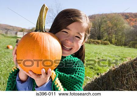 Girl holding a pumpkin View Large Photo Image Stock Image - Girl holding a pumpkin. Fotosearch