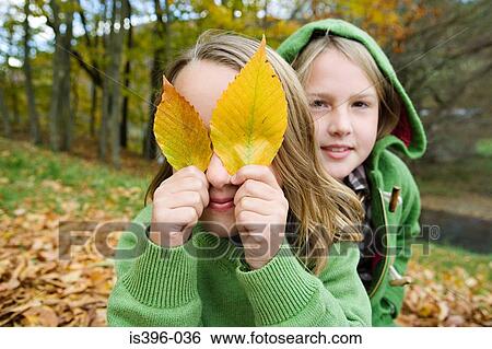 Girls playing with leaves View Large Photo Image Stock Photograph - Girls playing with leaves. Fotosearch