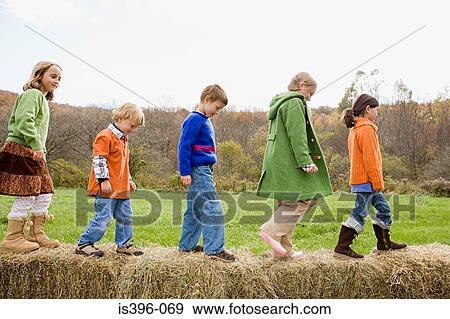 Stock Photo - Kids walking on hay bales. Fotosearch