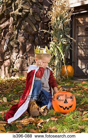 Sullen boy looking at jack o lantern View Large Photo Image Stock Photo - Sullen boy looking at jack o lantern. Fotosearch