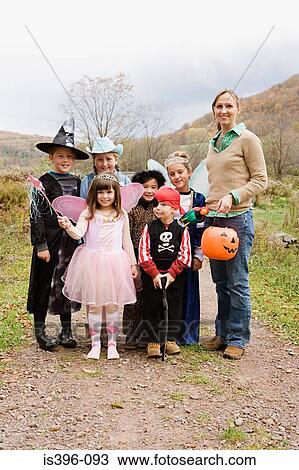 Stock Image - Woman and children in halloween costumes. Fotosearch