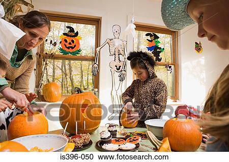 Woman and kids carving pumpkins View Large Photo Image Stock Image - Woman and kids carving pumpkins. Fotosearch