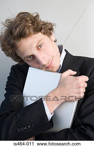 Man holding a laptop View Large Photo Image Stock Image - Man holding a laptop. Fotosearch