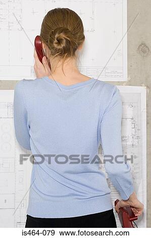 Woman on telephone looking at blueprints View Large Photo Image Stock Photo - Woman on telephone looking at blueprints. Fotosearch