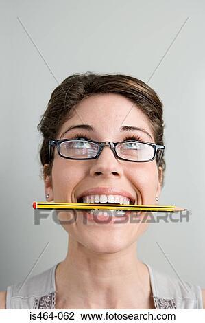 Stock Image - Woman with pencil in her mouth. Fotosearch