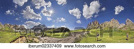 Stock Photo - "360 panoramic view of the Geisler Mountains, two hikers walking near Mittagsscharte gorge, Puez-Geisler Nature Park, province of Bolzano-Bozen, Italy, Europe". Fotosearch