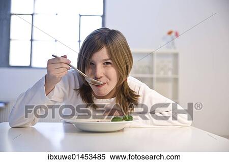 Stock Photography - A girl eating soup. Fotosearch