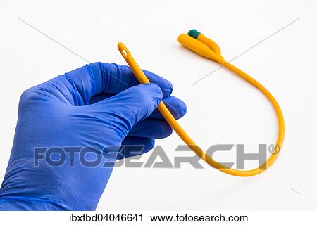 Stock Image - A hand with a blue medical glove is holding a balloon catheter. Fotosearch