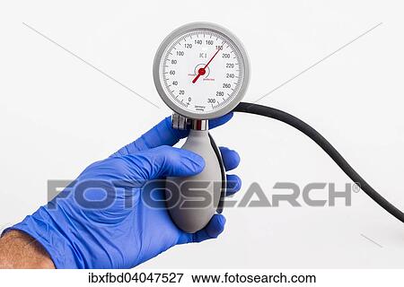 "A hand with a blue medical glove is holding a sphygmomanometer, blood pressure meter, indicating high blood pressure" View Large Photo Image Stock Photo - "A hand with a blue medical glove is holding a sphygmomanometer, blood pressure meter, indicating high blood pressure". Fotosearch