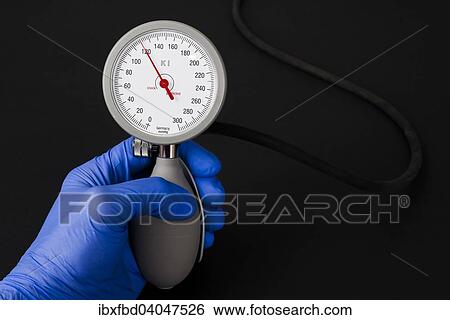 "A hand with a blue medical glove is holding a sphygmomanometer, blood pressure meter, indicating normal blood pressure" View Large Photo Image Stock Photograph - "A hand with a blue medical glove is holding a sphygmomanometer, blood pressure meter, indicating normal blood pressure". Fotosearch
