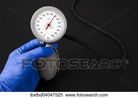 "A hand with a blue medical glove is holding a sphygmomanometer, blood pressure meter, indicating high blood pressure" View Large Photo Image Stock Photography - "A hand with a blue medical glove is holding a sphygmomanometer, blood pressure meter, indicating high blood pressure". Fotosearch