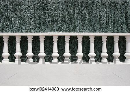 Stock Image - "A white stone balustrade in front of an artificial green hedge, Menorca, Balearic Islands, Spain, Europe". Fotosearch